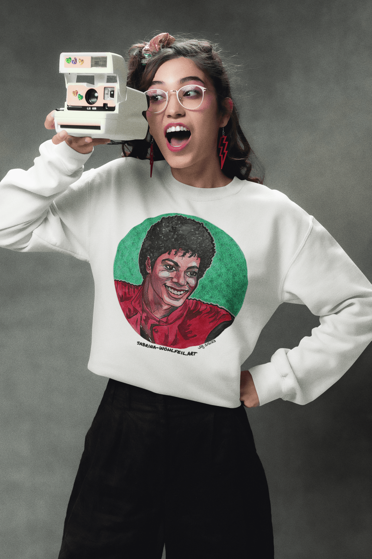 Person wearing Michael Jackson - Aquarell Print Comic Sketch - Klassisches Unisex Sweatshirt mit Rundhalsausschnitt holding a vintage camera.