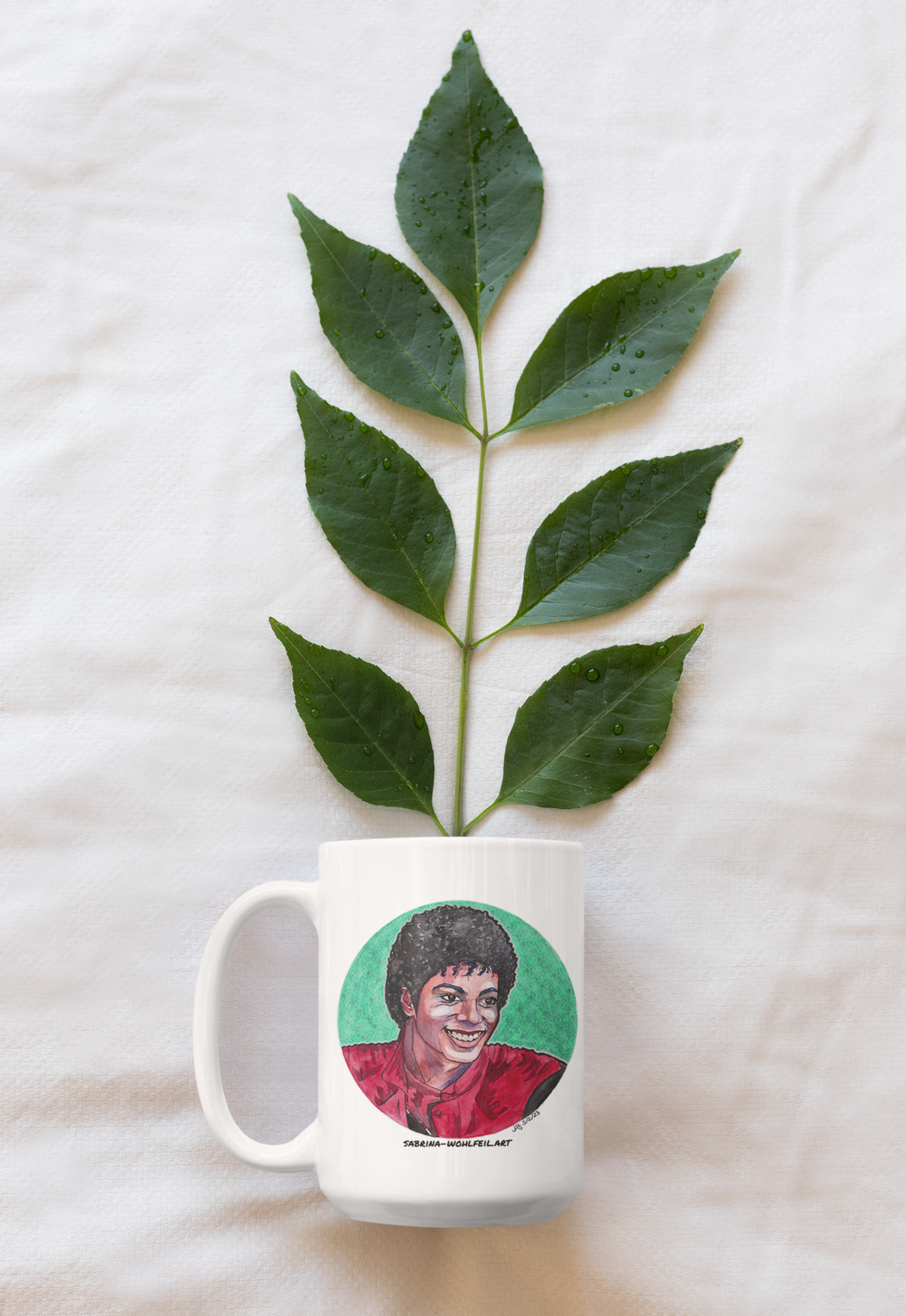 Weiße Keramiktasse mit Aquarellporträt von Michael Jackson, C-förmiger Henkel, glänzendes Finish, und einem grünen Blatt im Hintergrund